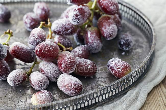 Vista de cerca de las uvas azucaradas en bandeja de metal con dibujos - foto de stock