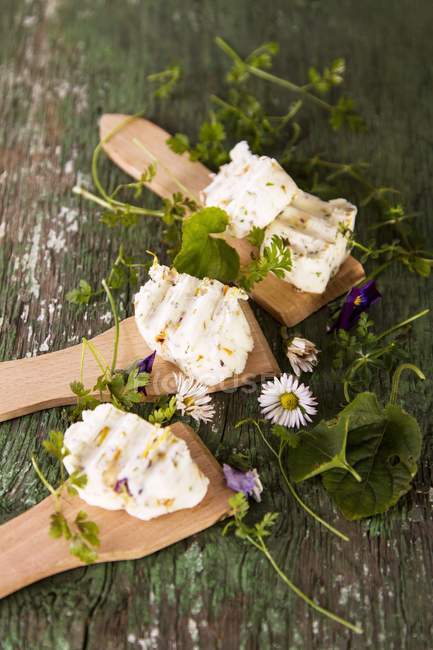Vista elevata di burro di fiori con fiori e foglie su superficie di legno — Foto stock