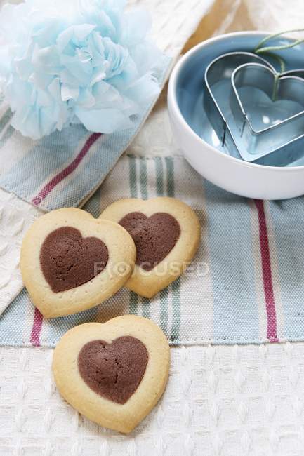 Heart-shaped biscuits and cutters — Stock Photo