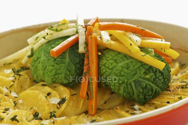 Gratin di patate con verza e verdure a radice su fondo bianco — Foto stock