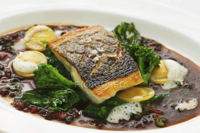 Fried sea bass in olive gravy — Stock Photo