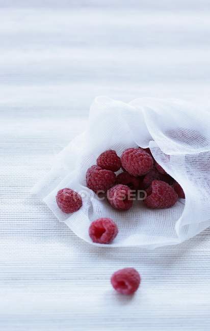 Raspberries on piece of fabric — Stock Photo