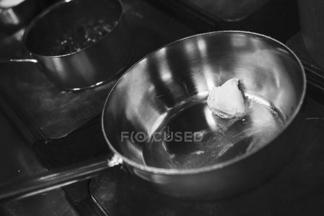Vista close-up de manteiga derretendo em uma panela no fogão — Fotografia de Stock