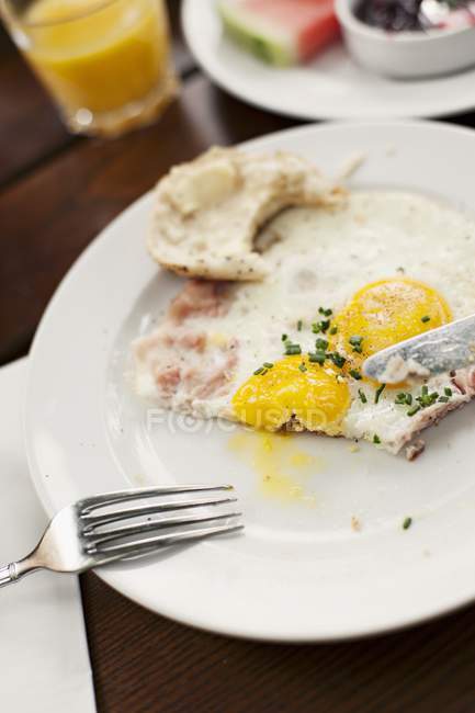 Жареное яйцо с беконом и роллом — стоковое фото