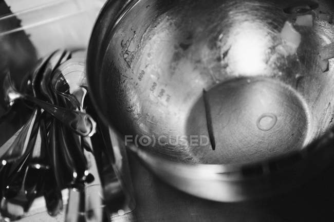 Vista de primer plano de un recipiente de medición de acero inoxidable con restos de ensalada y cubiertos - foto de stock