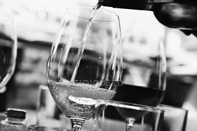 Vista close-up de derramar vinho branco em um copo — Fotografia de Stock