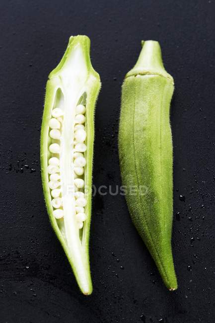 Gousses d'okra entières et coupées en deux — Photo de stock