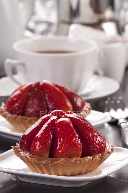 Strawberry tartlets with cup of coffee — Stock Photo