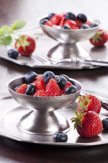 Strawberries and blueberries in metal stand — Stock Photo