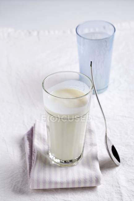 Mantequilla de leche en vidrio sobre tela - foto de stock