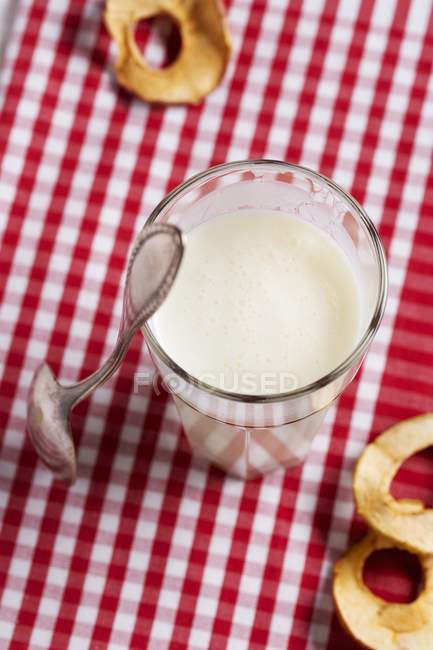 Vaso de leche de mantequilla y anillos de manzana - foto de stock