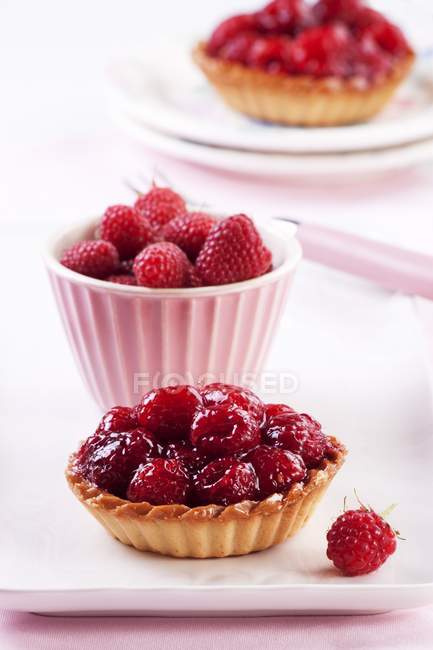 Raspberry tartlet and fresh raspberries — Stock Photo
