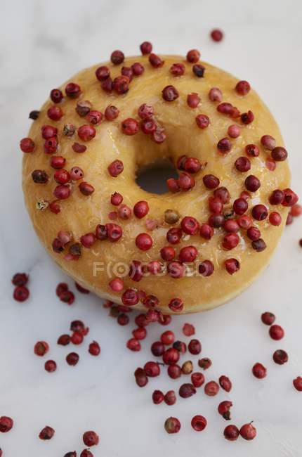 Doughnut decorated with pink peppercorns — Stock Photo