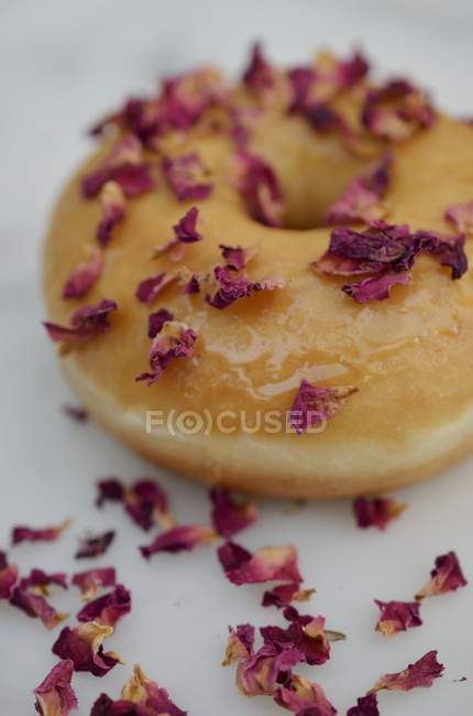 Doughnut decorated with rose petals — Stock Photo