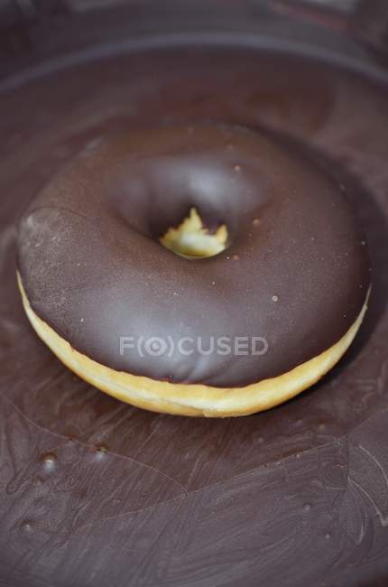 Closeup view of one chocolate glazed donut — Stock Photo