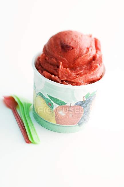 Tub of strawberry sorbet with spoons — Stock Photo