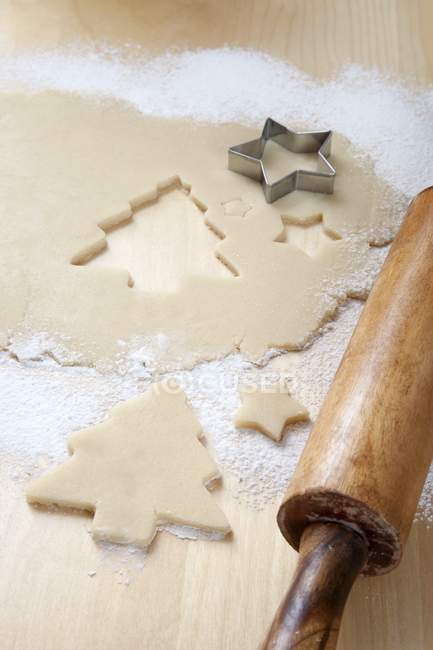 Vue rapprochée du sapin de Noël et des formes étoilées découpées en pâte sucrée — Photo de stock