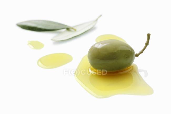 Olive in a pool of olive oil — Stock Photo