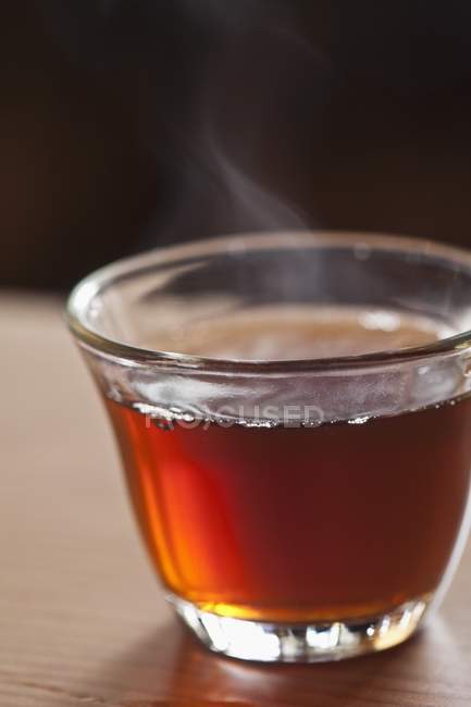 Copa de vidrio de té caliente al vapor - foto de stock