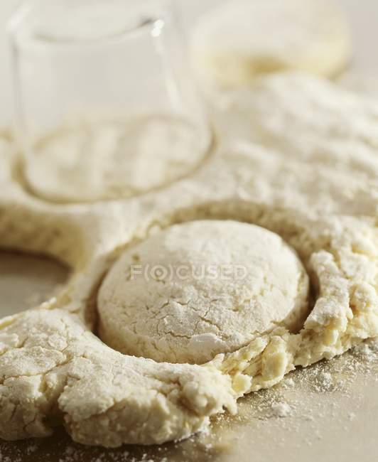 Closeup view of cutting rounds out of dough for homemade biscuits — Stock Photo