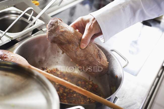 Hand holds tenderloin beef — Stock Photo