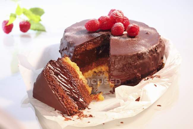 Pastel de chocolate cubierto con frambuesas - foto de stock