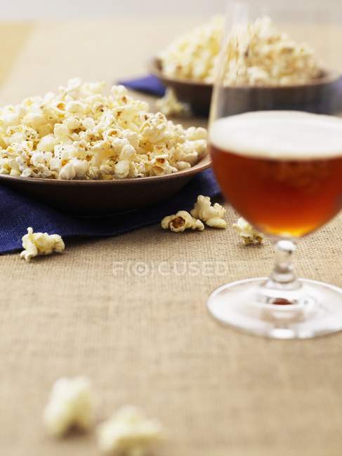 Popcorn on plates and beer — Stock Photo
