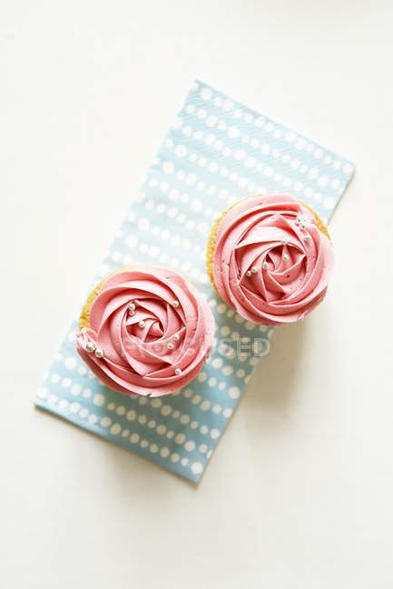 Deux cupcakes décorés avec de la crème de fraise — Photo de stock