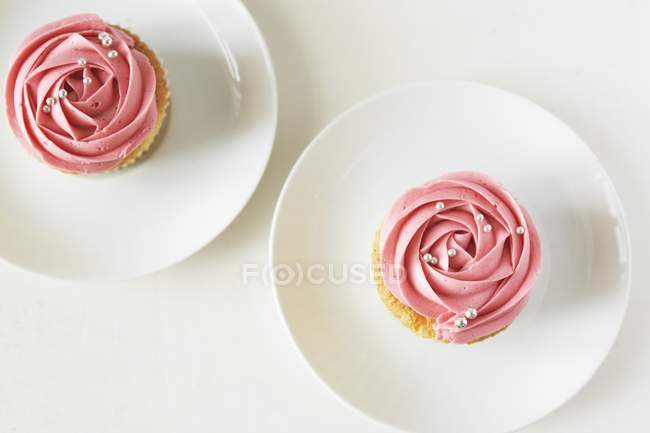 Zwei Cupcakes mit Erdbeercreme verziert — Stockfoto