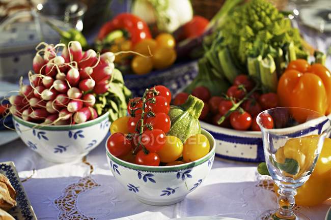 Verduras de verão frescas em uma mesa em potes e tigelas sobre a mesa — Fotografia de Stock