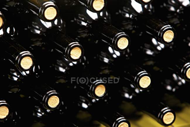 Vista de primer plano de una pila de botellas de vino - foto de stock