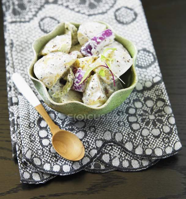 Картофельный салат с треской и полотенце на столе — стоковое фото