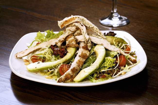 Vista close-up de salada de frango com manga e legumes no prato — Fotografia de Stock