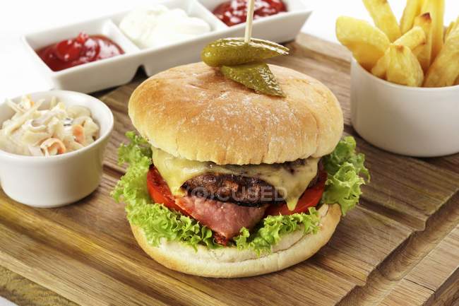 Cheeseburger and chips on desk — Stock Photo