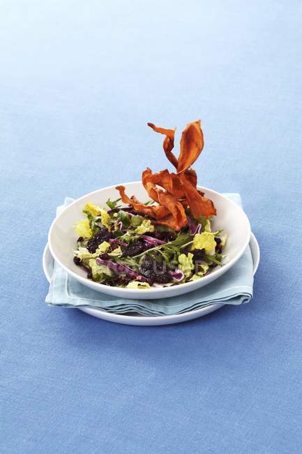 Mixed leaf salad with red cabbage, Brazil and fried sweet potatoes on plate with napkin — Stock Photo