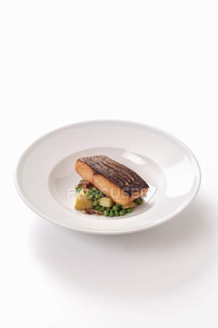 Salmon fillet on a bed of peas — Stock Photo