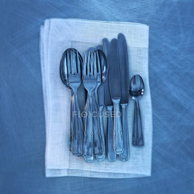 Top view of old cutlery on a linen napkin in blue light — Stock Photo