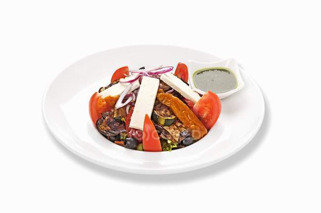 Tomatensalat mit Zucchini und Feta auf weißem Teller vor weißem Hintergrund — Stockfoto