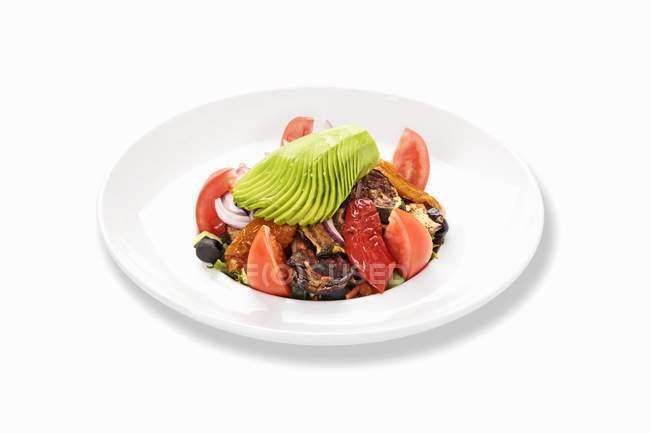 Ein Gemüsesalat mit getrockneten Tomaten auf weißem Teller vor weißem Hintergrund — Stockfoto
