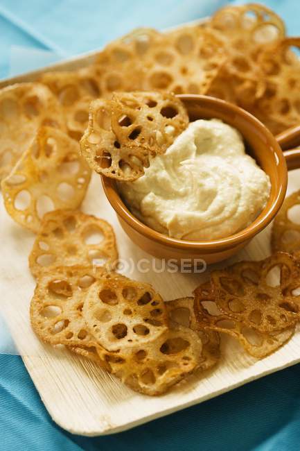 Fried Sliced Lotus Root with Dip on white plate over blue surface — Stock Photo