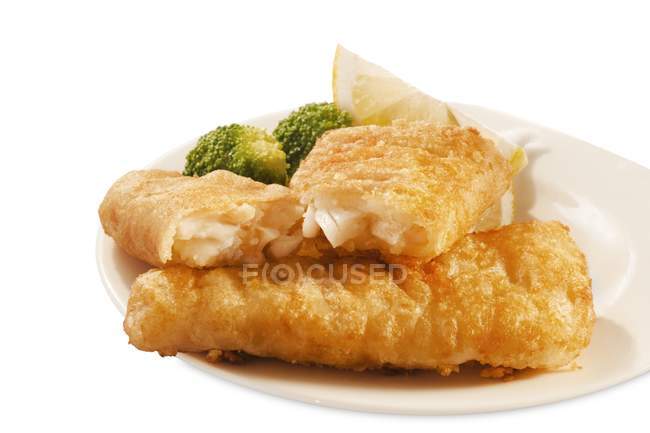 Closeup view of battered fish sticks with broccoli and lemon — Stock Photo