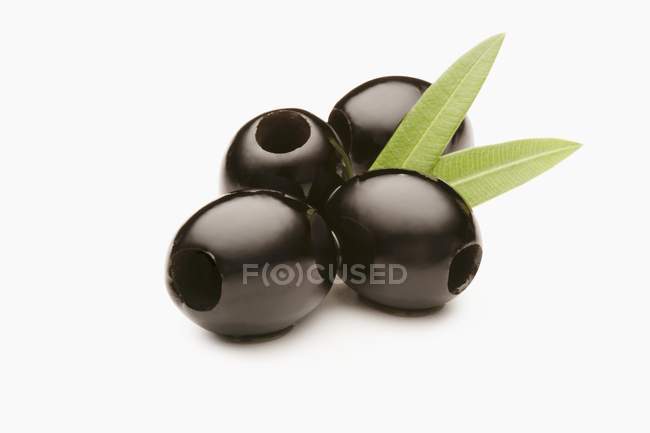 Черные оливки с листьями — стоковое фото
