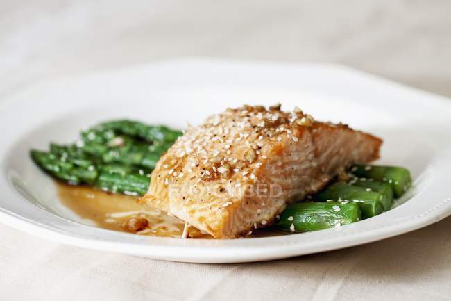 Filete de salmón sobre espárragos verdes - foto de stock
