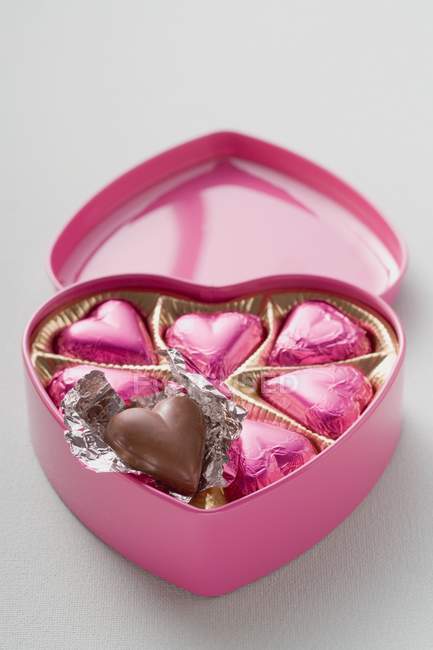 Chocolates in heart-shaped box — Stock Photo