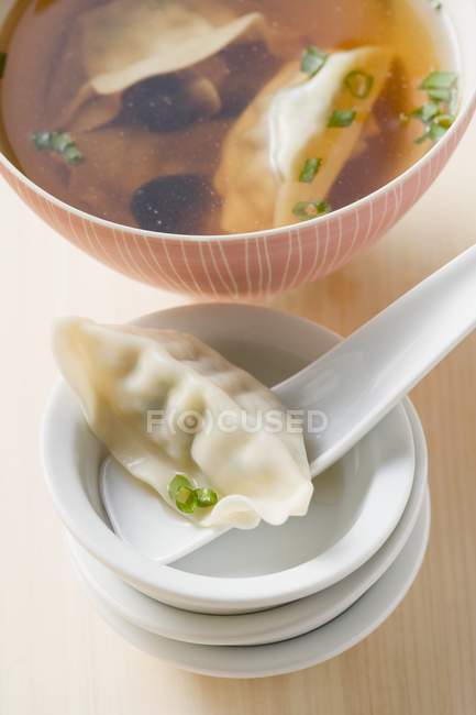Closeup view of clear broth with Wontons and mushrooms — Stock Photo