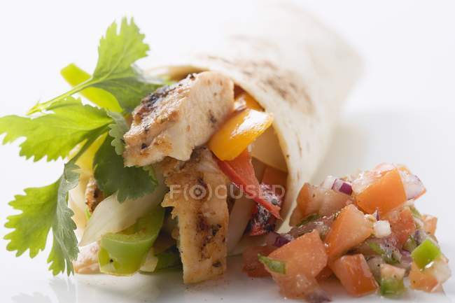 Closeup view of wrap filled with chicken and pepper by salsa — Stock Photo