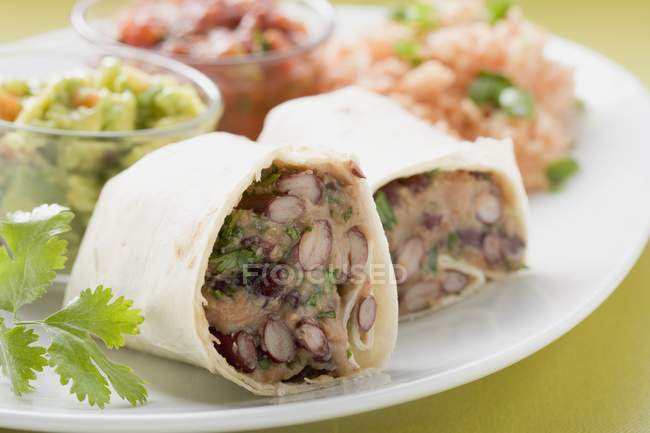 Burritos de haricots avec accompagnement sur plaque blanche — Photo de stock
