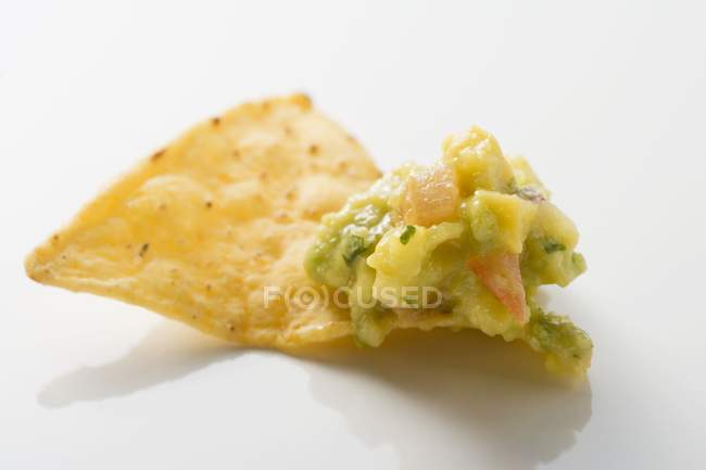 Guacamole em nacho na superfície branca — Fotografia de Stock