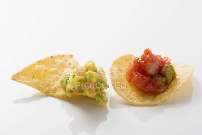 Guacamole sur nacho, salsa sur copeau de tortilla sur fond blanc — Photo de stock