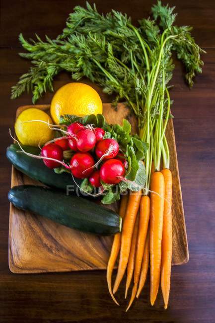 Légumes entiers frais sur une planche à découper — Photo de stock